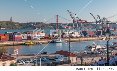 Skyline over Lisbon commercial port timelapse, 25th April Bridge, containers on pier with freight cranes 114820759