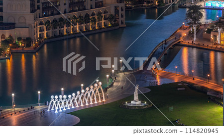Top close up view of the bridge over man-made lake and some people walking in park 114820945