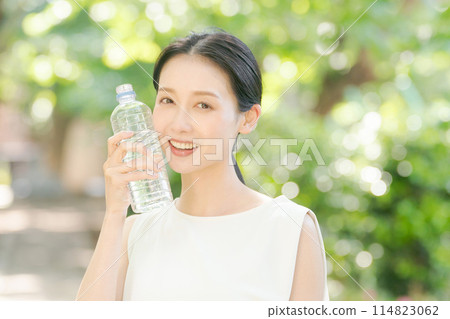 A woman drinking water in nature 114823062