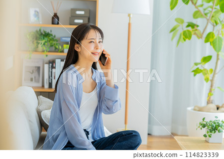 年輕女子在客廳用智慧型手機交談 114823339