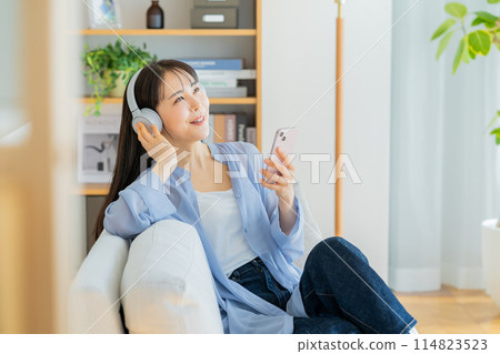 一個年輕女子在沙發上放鬆 114823523