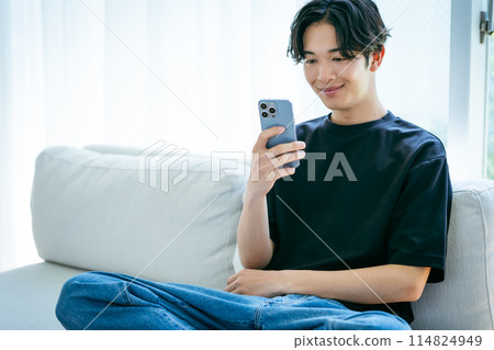 操作智能手機的一個年輕人 114824949