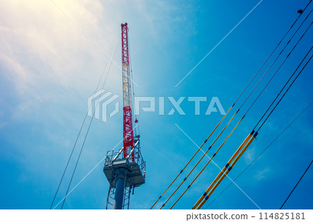 起重機和電線保護罩延伸到藍天,暖色調 起重機和電線保護罩延伸到藍天,暖色調 114825181