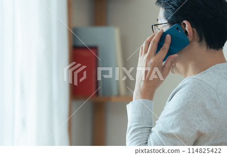 Middle-aged man talking on smartphone Middle-aged man talking on smartphone 114825422