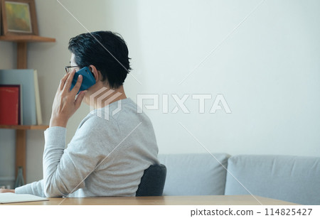 Middle-aged man talking on smartphone Middle-aged man talking on smartphone 114825427