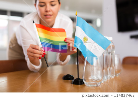 Little flag of Argentina on table and LGBT flag put next to it by young woman Little flag of Argentina on table and LGBT flag put next to it by young woman 114827462