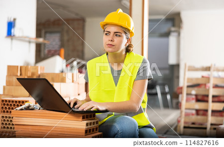 Woman with laptop on indoor construction site 114827616