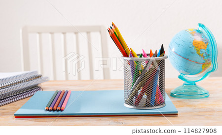 Closeup of color pencils, wax chalks, globe and notebooks. School supplies 114827908