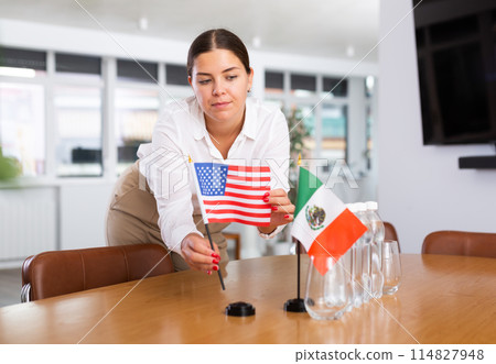 Young lady sets miniatures flags of Mexico and USA for international negotiations Young lady sets miniatures flags of Mexico and USA for international negotiations 114827948