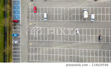 An aerial view of a parking lot filled with parked cars 114829598