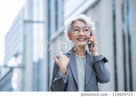 辦公區有智慧型手機的高級女性 辦公區有智慧型手機的高級女性 114829723