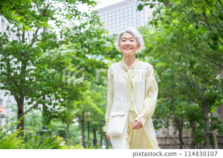 Senior woman walking in the greenery Senior woman walking in the greenery 114830107