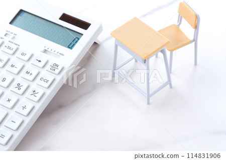 課桌、椅子和計算器給人一種教育成本持續上漲並給家庭預算帶來壓力的印象。 課桌、椅子和計算器給人一種教育成本持續上漲並給家庭預算帶來壓力的印象。 114831906