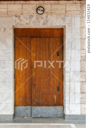 old wooden door of soviet public building in a wall made of shell rock and marble 114832429