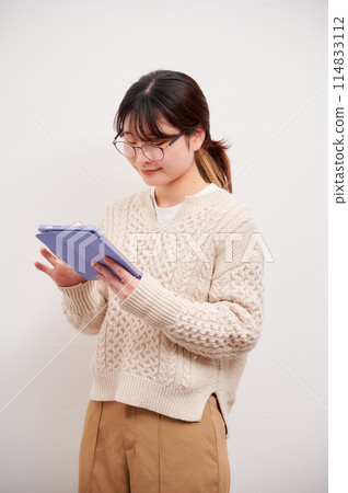 A woman who operates a tablet 114833112