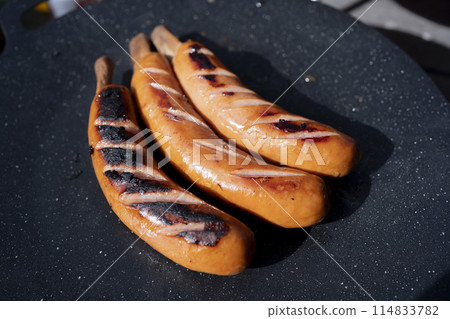 Bone-in sausages cooked on a multi-griddle Bone-in sausages cooked on a multi-griddle 114833782