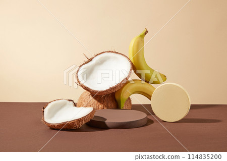 Blank circular platform in brown color next to a yellow podium, in the back are avocados and bananas stacked on top of each other, over light yellow background. Template for design, space for text Blank circular platform in brown color next to a yellow podium, in the back are avocados and bananas stacked on top of each other, over light yellow background. Template for design, space for text 114835200