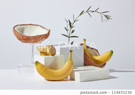 Stock for advertise products has banana and coconut origin on white background with various sizes of blank podium for displaying. Photo of frontal shot has blank space for adding text Stock for advertise products has banana and coconut origin on white background with various sizes of blank podium for displaying. Photo of frontal shot has blank space for adding text 114835230