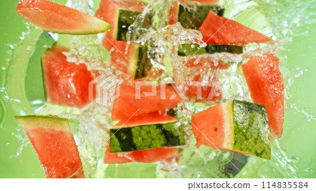 Freeze Motion of Flying Water Melon Slices into Water, Colored Background. 114835584