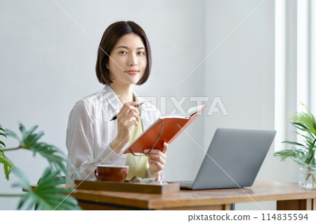 Young woman operating a personal computer in the room 114835594