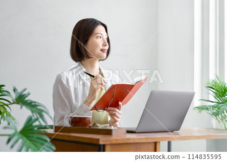 年輕女子在房間裡操作電腦 114835595