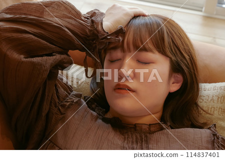 Unwell woman lying on the sofa 114837401