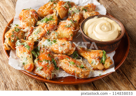 Classic Garlic Parmesan Butter Chicken Wings served with mayonnaise close-up in a plate. Horizontal 114838033