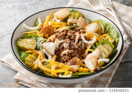 Cheeseburger, hamburger or burger keto salad with crunchy lettuce, creamy burger sauce, ground beef, pickles, cheese and onions closeup on the bowl. Horizontal 114838051