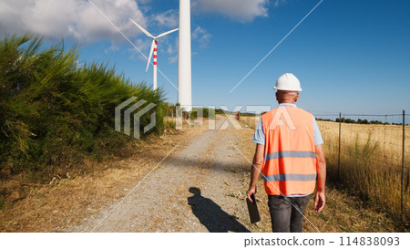 Engineer Walking Under Wind Turbines Engineer Walking Under Wind Turbines 114838093