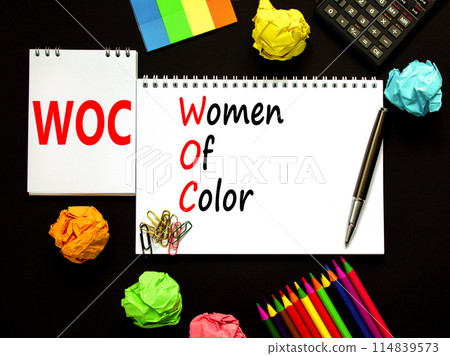 WOC women of color symbol. Concept words WOC women of color on beautiful white note. Beautiful black background. Black calculator. Business WOC women of color social issues concept. Copy space. 114839573