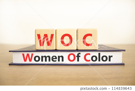 WOC women of color symbol. Concept words WOC women of color on beautiful wooden blocks and book. Beautiful white background. Business WOC women of color social issues concept. Copy space. 114839643