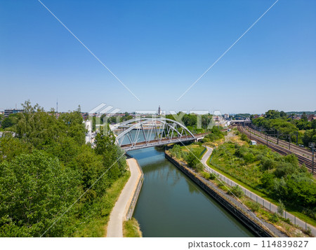 Enjoy a picturesque aerial perspective of an urban bridge over a river in the sunlight 114839827