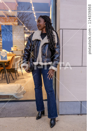 Stylish Woman in Leather Jacket Outside Modern Caf 114839868