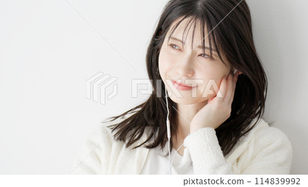 Woman listening to music in bed 114839992