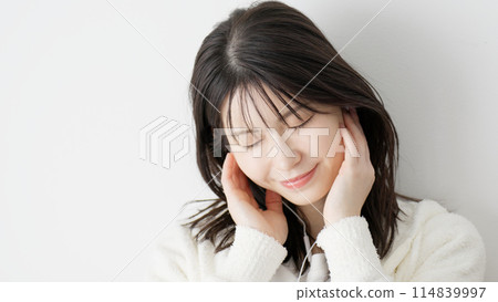 Woman listening to music in bed 114839997