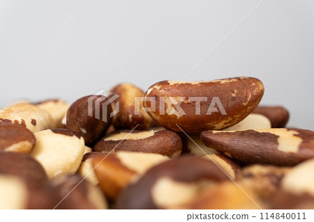 Macro brazil nuts on light grey background. 114840011