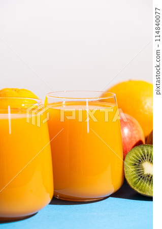 Multi-fruit juices in glasses among fresh fruits. Multi-fruit juices in glasses among fresh fruits. 114840077