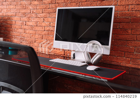 Workplace at home with a candy bar and wireless devices against a brick wall 114840219