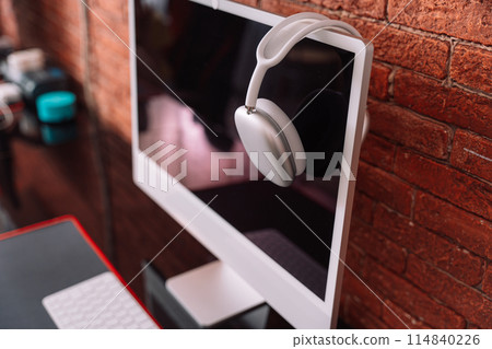 Wireless headphones hanging on a monoblock on a black table Wireless headphones hanging on a monoblock on a black table 114840226