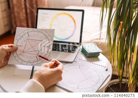 An astrologer draws with a pencil on a natal chart An astrologer draws with a pencil on a natal chart 114840273