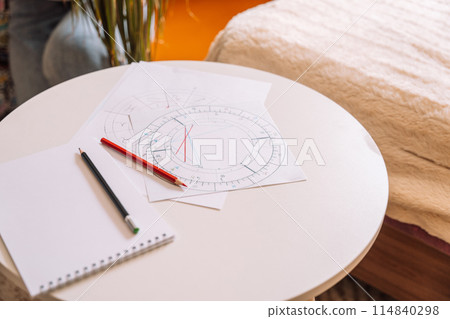 Natal chart on white paper with pencils on a round table Natal chart on white paper with pencils on a round table 114840298
