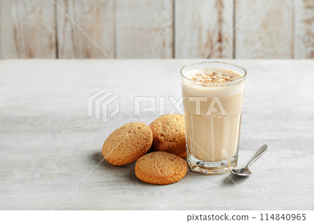 coffee raff in a glass close-up with homemade cookies. coffee with milk and grated nut on light background. coffee raff in a glass close-up with homemade cookies. coffee with milk and grated nut on light background. 114840965