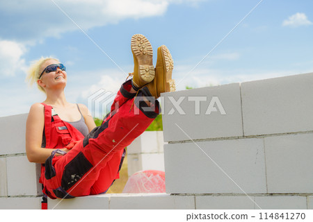 Woman taking break on construction site Woman taking break on construction site 114841270