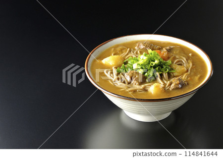 Curry soba noodles with plenty of green onions photographed against a black background Curry soba noodles with plenty of green onions photographed against a black background 114841644