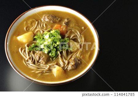 Aerial view of curry soba noodles with plenty of green onions on a black background Aerial view of curry soba noodles with plenty of green onions on a black background 114841785