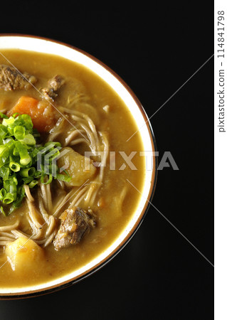 黑色背景下咖哩蕎麥麵的頭頂照片,上面有大量的蔥 黑色背景下咖哩蕎麥麵的頭頂照片,上面有大量的蔥 114841798