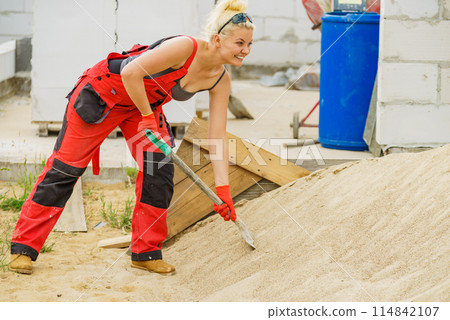 Woman using shovel on constriction site 114842107