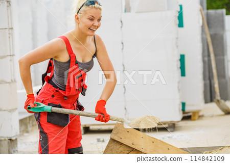 Woman using shovel on constriction site Woman using shovel on constriction site 114842109