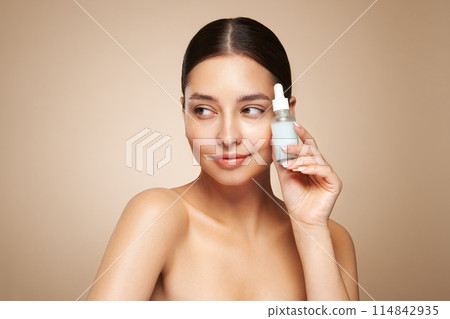 Woman holding a cosmetic jar of oil serum 114842935