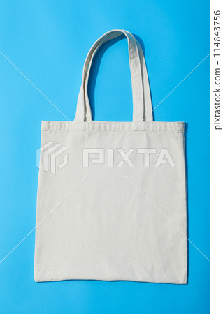 A white bag lies on a blue background 114843756